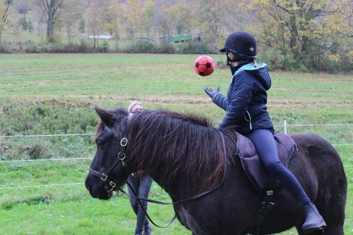 Kind bei einer Reitübung mit Ball