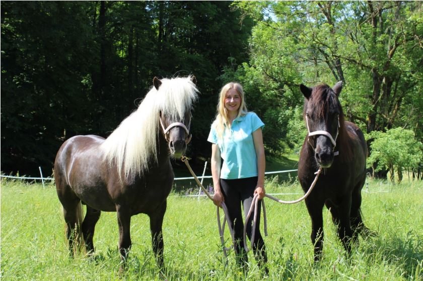 Anina Winter mit zwei Pferden auf der Weide